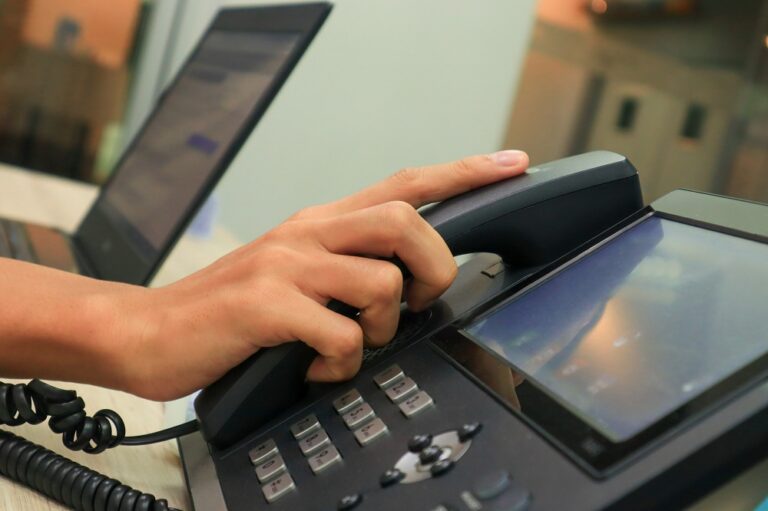 Un impiegato sta usando un telefono sulla propria scrivania